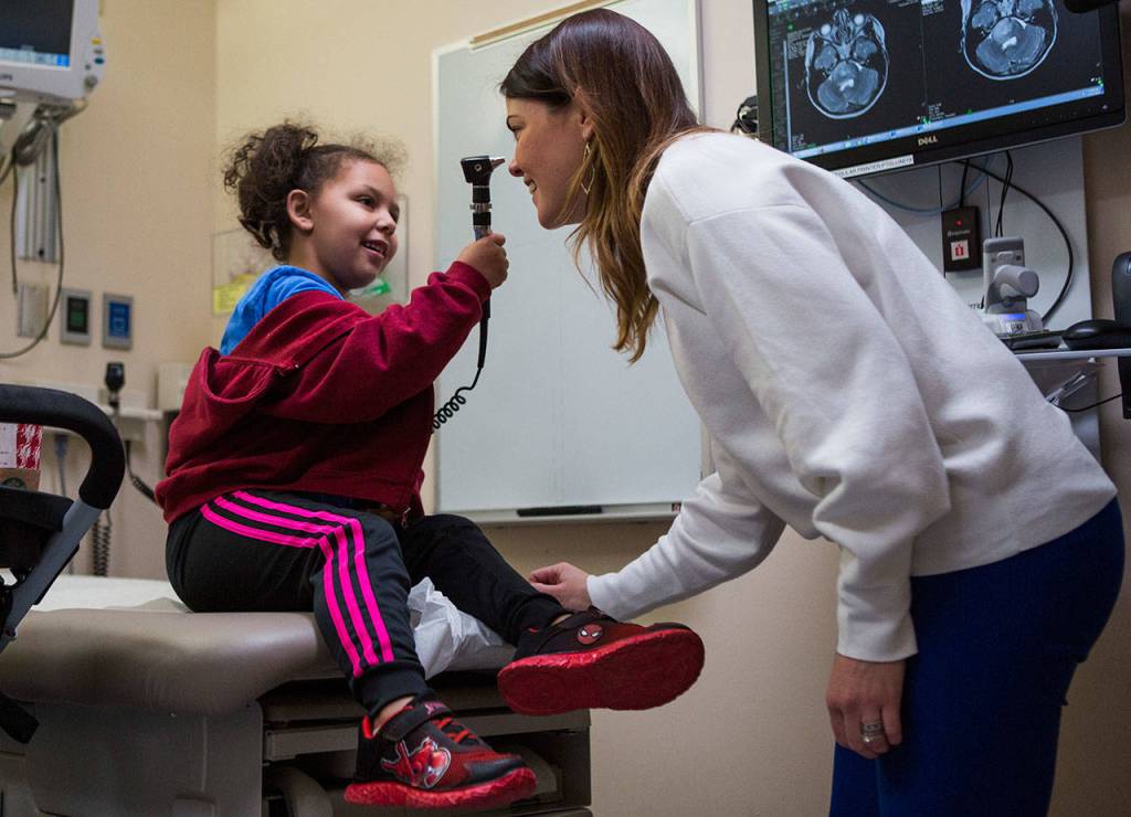 Kaya uses an otoscope on her her nurse Susan Holtzclaw during her appointment to go over scan results and to evaluate her symptoms at Seattle Childrens Hospital on Dec. 12, 2018. (Olivia Vanni / The Herald)