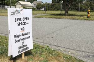 Signs have popped up in the Port Gardner neighborhood against a proposal by the Everett School District and Housing Hope to build affordable housing on a playfield on Norton Avenue. (Lizz Giordano / The Herald)