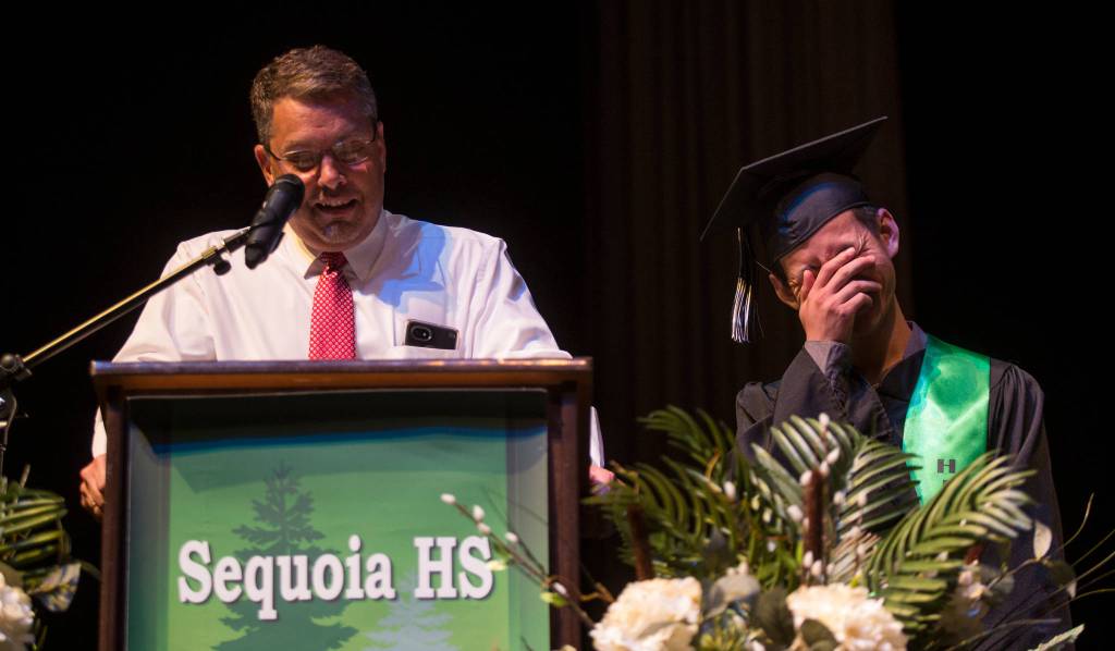 Student Andy Pham gets a bit embarrassed as teacher Jack Roy talks about him during the Sequoia High graduation ceremony held in the Everett Civic Auditorium on Thursday, June 13, 2019 in Everett, Wash. (Andy Bronson / The Herald)