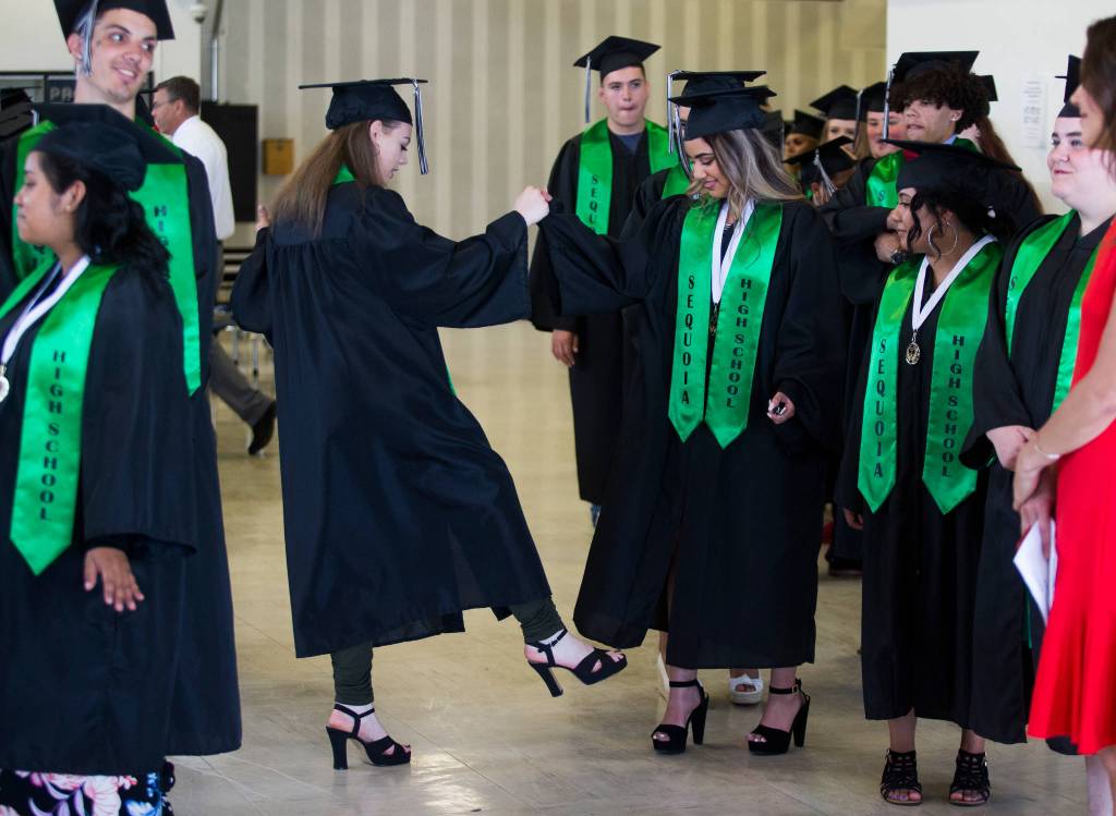 Vanessa ONeal, left, teaches Wendy Rivera-Garcia the Kid-N-Play dance move before the Sequoia High graduation ceremony held in the Everett Civic Auditorium on Thursday, June 13, 2019 in Everett, Wash. (Andy Bronson / The Herald)