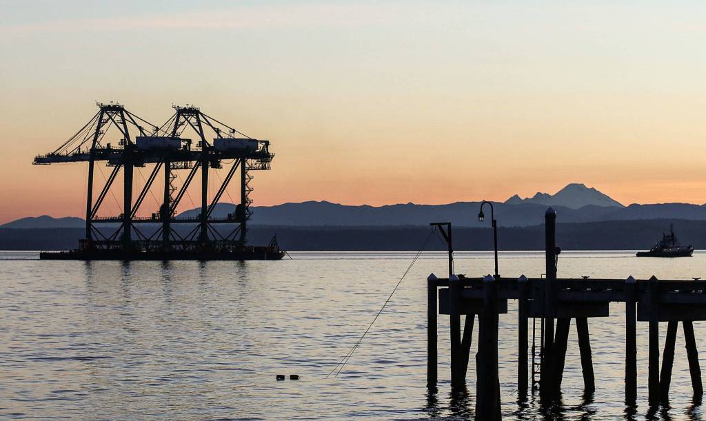 A pair of newly acquired port cranes make their way though the sound off the shores of Mukilteo, after a 1,400-mile ocean journey from Los Angeles, on June 11. (Kevin Clark / The Herald)