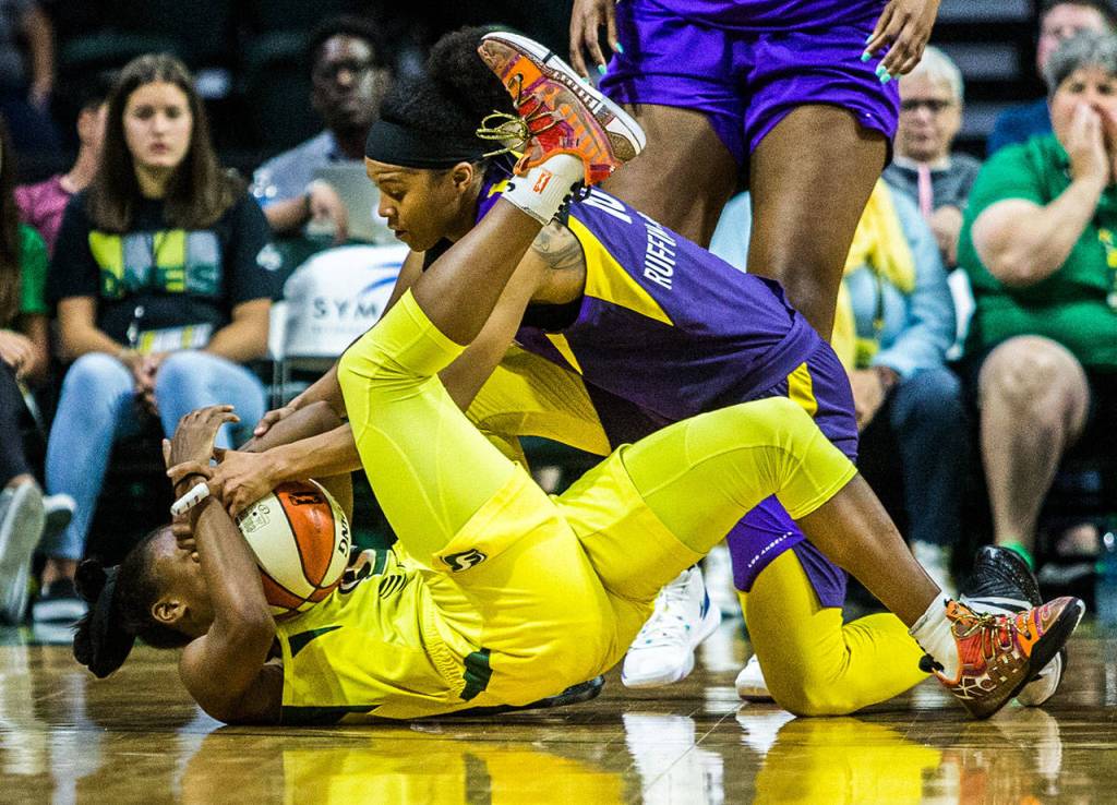 The Storms Jewell Loyd (bottom) scrambles for the ball with the Sparks Tierra Ruffin-Pratt during a game on June 21, 2019, at Angel of the Winds Arena in Everett. (Olivia Vanni / The Herald)