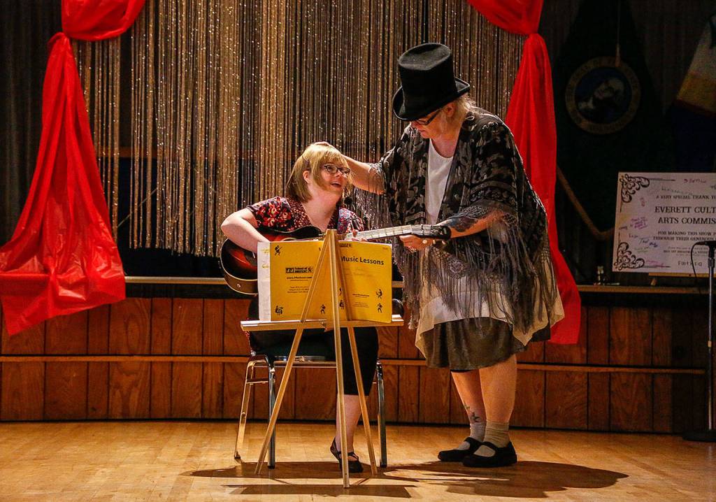 Show director Heidi Heimarck helps singer-guitarist Megan Harrell at the start of Way Off Broadway, a talent show staged by All Aboard. The nonprofit provides recreation and other programs for adults with special needs. (Dan Bates / The Herald)