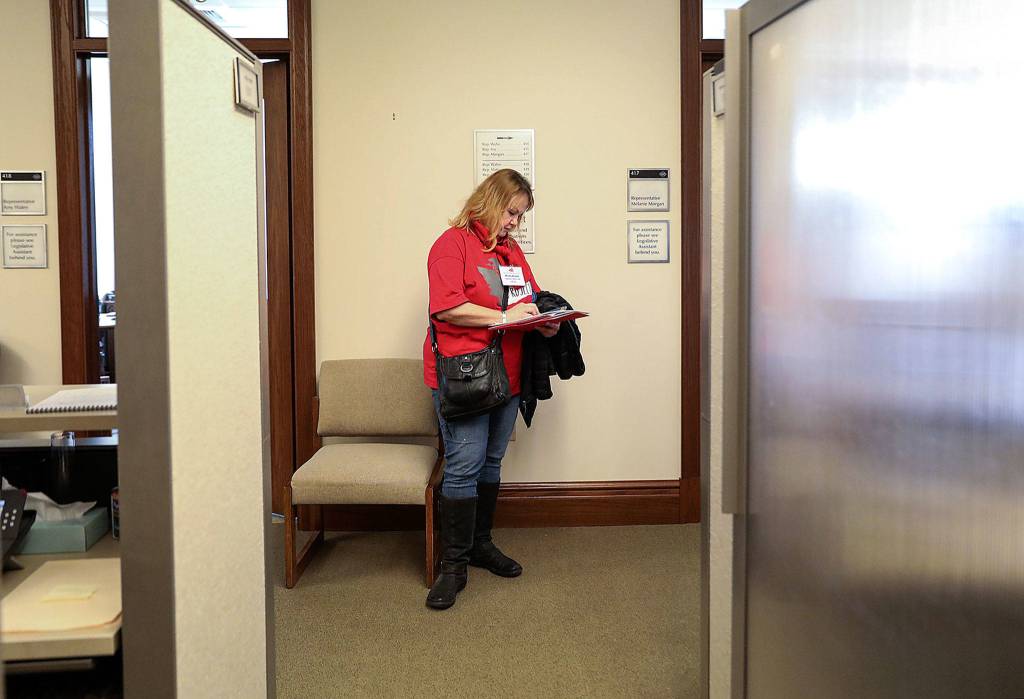 Mindy Woods takes a break between meetings with legislators to check her schedule during Housing and Homelessness Advocacy Day. (Lizz Giordano / The Herald)