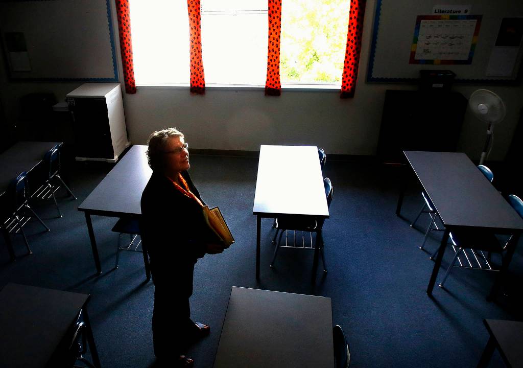 Carrying a scrapbook filled with photos and memories of former students, special education teacher Susan Dow is ready to leave her Monroe High classroom for the last time. (Dan Bates / The Herald)