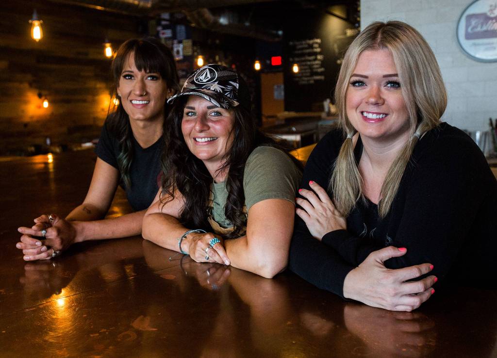 Mallory Galash (left) Alethea Kendrick (center) and Valerie Hackett have been bartending at The Bine in Bothell since the day it opened in August 2017. (Olivia Vanni / The Herald)