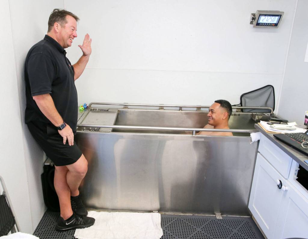 Brian Lee (left) goes over instructions for a body fat test with Andre Lino. (Kevin Clark / The Herald)