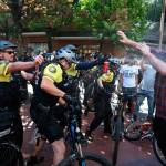 After a confrontation between authorities and protestors, police use pepper spray as multiple groups, including Rose City Antifa, the Proud Boys and others protest Saturday in downtown Portland, Oregon. In separate social media posts later in the day, police declared the situation to be a civil disturbance and warned participants faced arrest. (Dave Killen/The Oregonian via AP)
