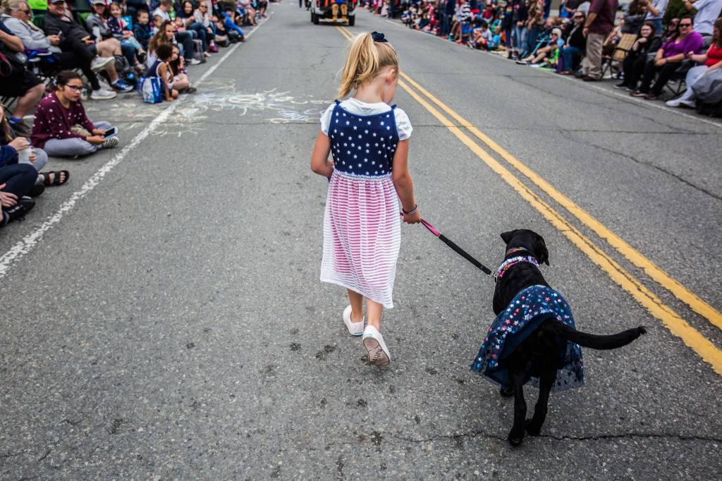 Clara Harper, 5, walks Laila, a Labrador retriever, during the Colors of Freedom Fourth of July Parade on Thursday, July 4, 2019 in Everett, Wash. (Olivia Vanni / The Herald)