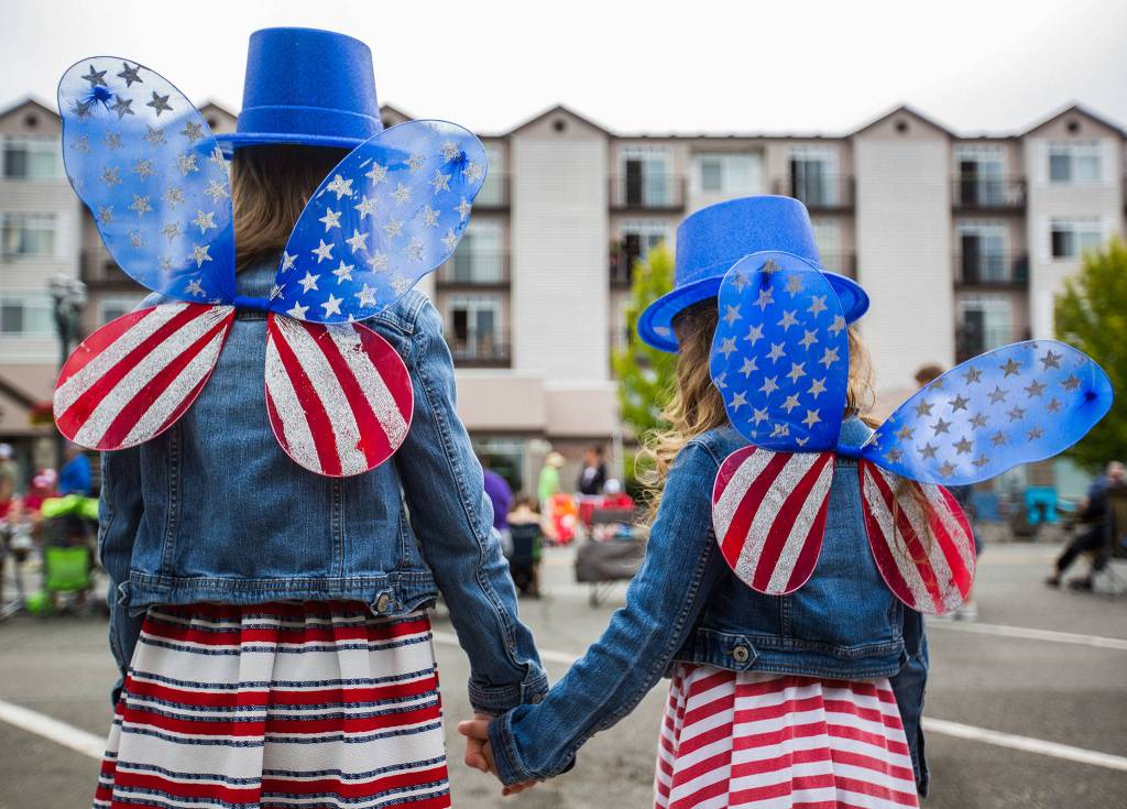 Audri Acosta, 8, and Valentina Acosta, 4, pose for a picture of their watching American flag fairy wings during the Colors of Freedom Fourth of July Parade on Thursday, July 4, 2019 in Everett, Wash. (Olivia Vanni / The Herald)