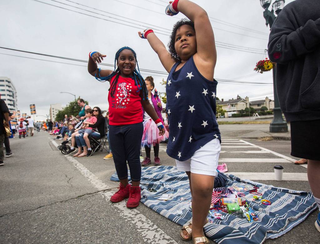 Gabrielle Jernigan, left, and cousin Dallas Minnifield, right, dance during the Colors of Freedom Fourth of July Parade on Thursday, July 4, 2019 in Everett, Wash. (Olivia Vanni / The Herald)
