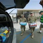 Members of the National Guard load water onto an SUV on Sunday in the aftermath of an earthquake outside Trona High School in Trona, California. (AP Photo/Marcio Jose Sanchez)