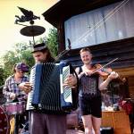 Everetts Jason Webley (center), violinist Ira Echo and another performer practice for the Flotsam River Circus aboard a hand-built vessel they plan to float on the Willamette River from Corvallis, Oregon, to Portland. (Photo by Lou Daprille)