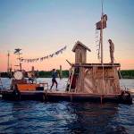 Everetts Jason Webley and other performers in the Flotsam River Circus plan to float this hand-built craft from Corvallis, Oregon, to Portland. Its pictured here on the Snohomish River. Webley is standing on the rooftop. (Photo by Lou Daprille)