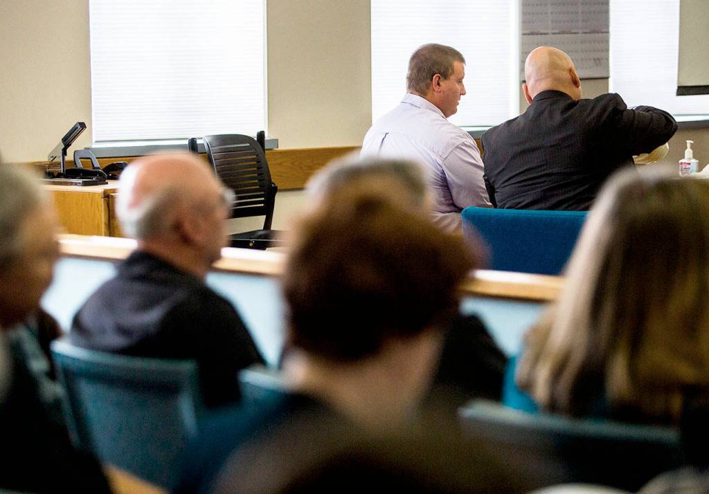 Michael Spieker (left) talks with attorney Jon Scott (right) during the closing arguments of Spiekers trial on May 16 in Everett. (Olivia Vanni / Herald file)
