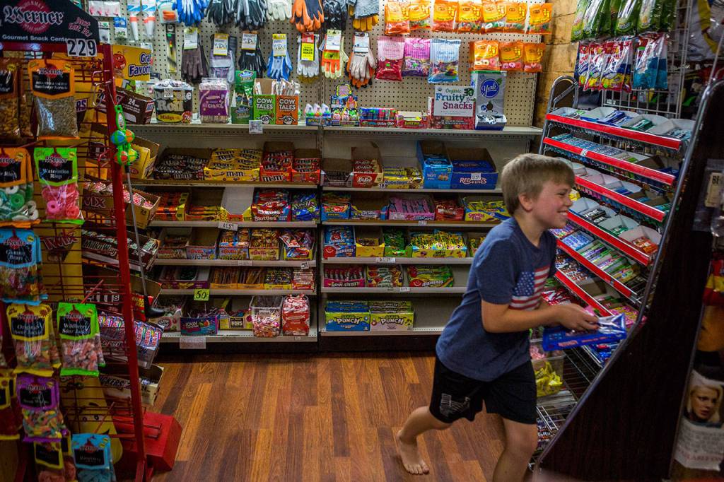 David Mattila laughs as he runs to the counter with his hands full of candy at Turners Neighborhood Grocery on Friday. (Olivia Vanni / The Herald)