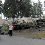 Neighbors gather at the scene Wednesday where the bodies of a mother and her three children were discovered after a fire that destroyed two mobile homes and two vehicles on Saturday at the Welcome Inn RV Park in Port Angeles. (Keith Thorpe/Peninsula Daily News)