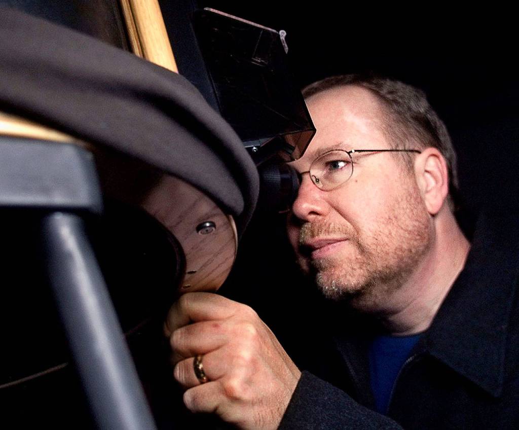 Mark Folkerts, president of the Everett Astronomical Society, looks at the moon through his 16-inch truss-tube Dobsonian reflector telescope in 2002. He sees the first manned moon landing as a major event in history. (Justin Best / Herald file)