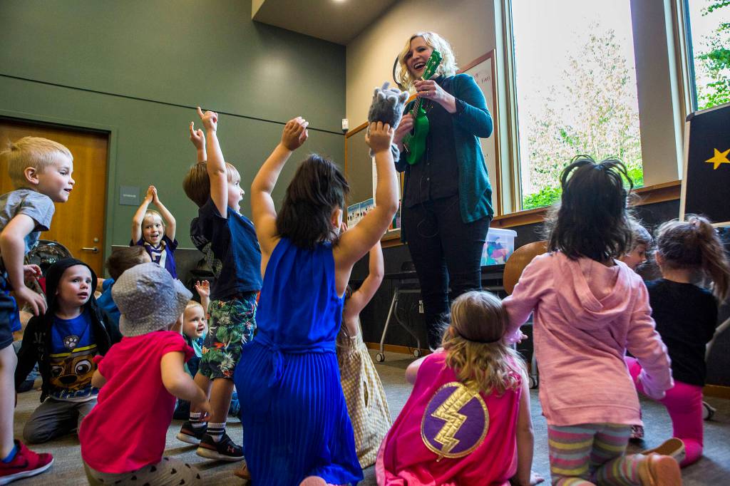Kids jump around for a rocket themed song being played by Shannon Horrocks during Ms. Shannons story time at the Snohomish Library on May 15 in Everett. (Olivia Vanni / The Herald)