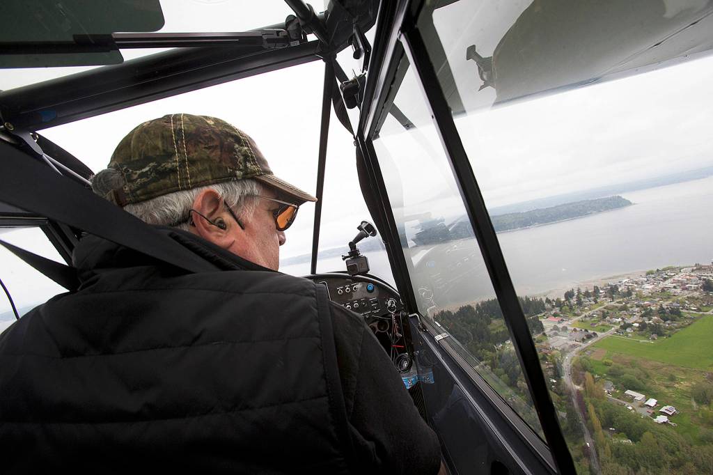 Pilot Dan Tarasievich looks down at the city of Langley after a coffee stop at Mukilteo Coffee Roasters as he flies home to Arlington on April 20 above Langley. (Andy Bronson / The Herald)