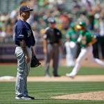 Mariners pitcher Tommy Milone (left) waits for the Athletics Chad Pinder (rear) to run the bases after Pinder homered in the sixth inning of a game on July 17, 2019, in Oakland, Calif. (AP Photo/Ben Margot)