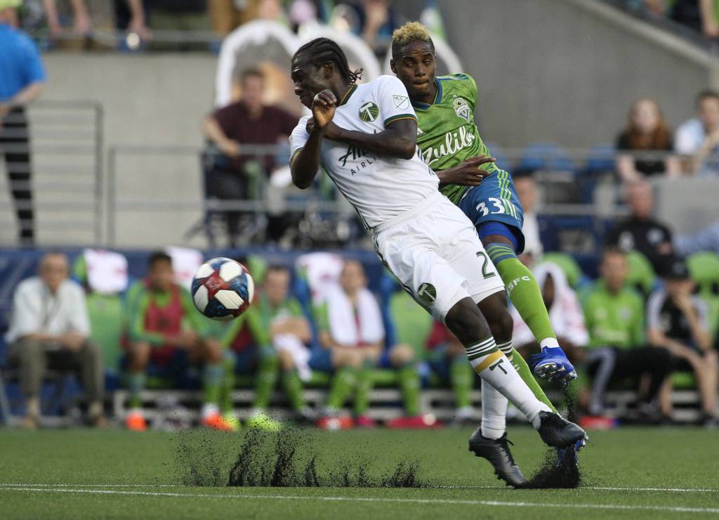 Joevin Jones takes shot around Diego Chara as the Seattle Sounders lost 2-1 to the Portland Timbers at CenturyLink Field on Sunday, July 21, 2019 in Seattle, Wash. (Andy Bronson / The Herald)