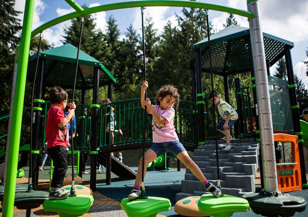 Violet Jensen, 5, navigates her way across a rope structure at Seaview Park on Wednesday in Edmonds. (Olivia Vanni / The Herald)