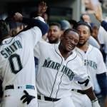 The Mariners Tim Beckham (right) celebrates in the dugout with Mallex Smith (0) after Beckham hit a grand slam during the third inning of a game against the Tigers on July 25, 2019, in Seattle. (AP Photo/Ted S. Warren)