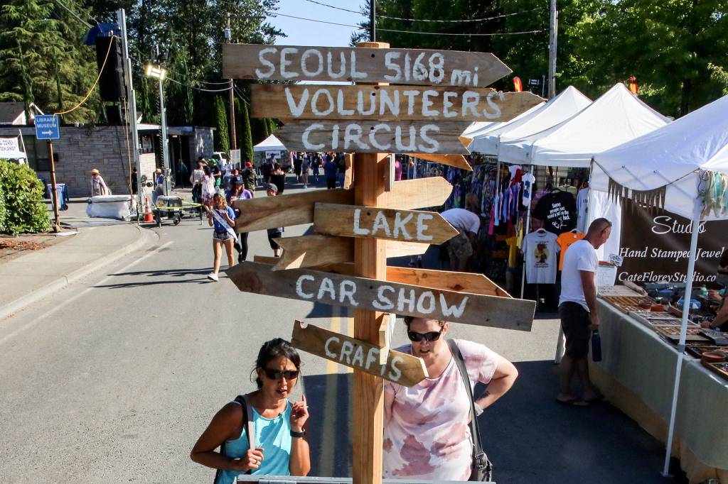 A signpost directs fair goers to the different available venues Friday afternoon during Lake Stevens Aquafest. (Kevin Clark / The Herald)