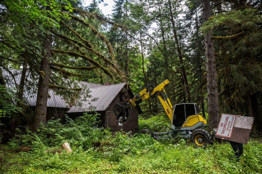 Manuel Garcia (right) of Multi-Corp Resources Inc. carries away a no trespassing sign from a building being demolished at Camp Silverton on July 6, 2019 in Silverton. (Olivia Vanni / The Herald)