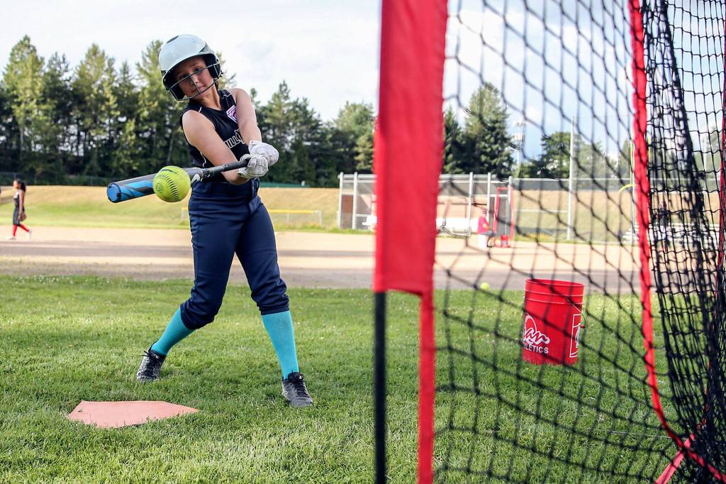 Kiana Holden swings during batting practice at Jackson High School in Mill Creek on July 16. (Kevin Clark / The Herald)