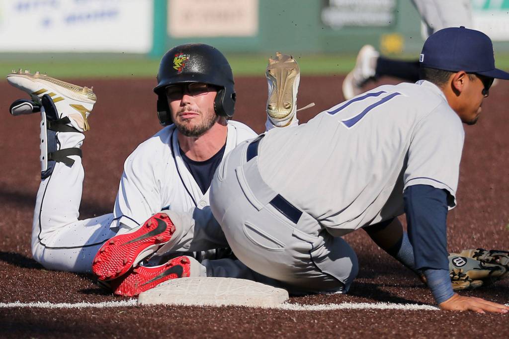The AquaSoxs Connor Hoover slides safely into third with the Dust Devils Kelvin Melean defending the base during a game on July 28, 2019, at Funko Field at Everett Memorial Stadium. (Kevin Clark / The Herald)