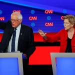Sen. Bernie Sanders, I-Vt., and Sen. Elizabeth Warren, D-Mass., talk during in the first of two Democratic presidential primary debates hosted by CNN on Tuesday in the Fox Theatre in Detroit. (AP Photo/Paul Sancya)