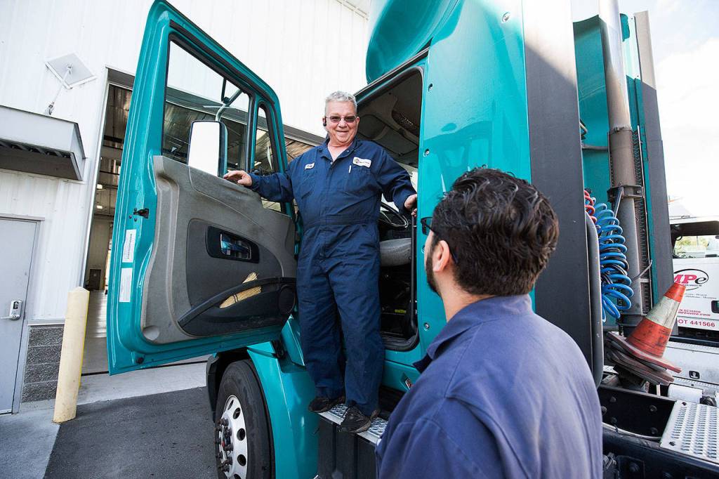Military veterans Jody Fuller (top) and Chris Nanez talk about a truck Fuller test-drove at Motor Trucks in Everett. (Andy Bronson / The Herald)