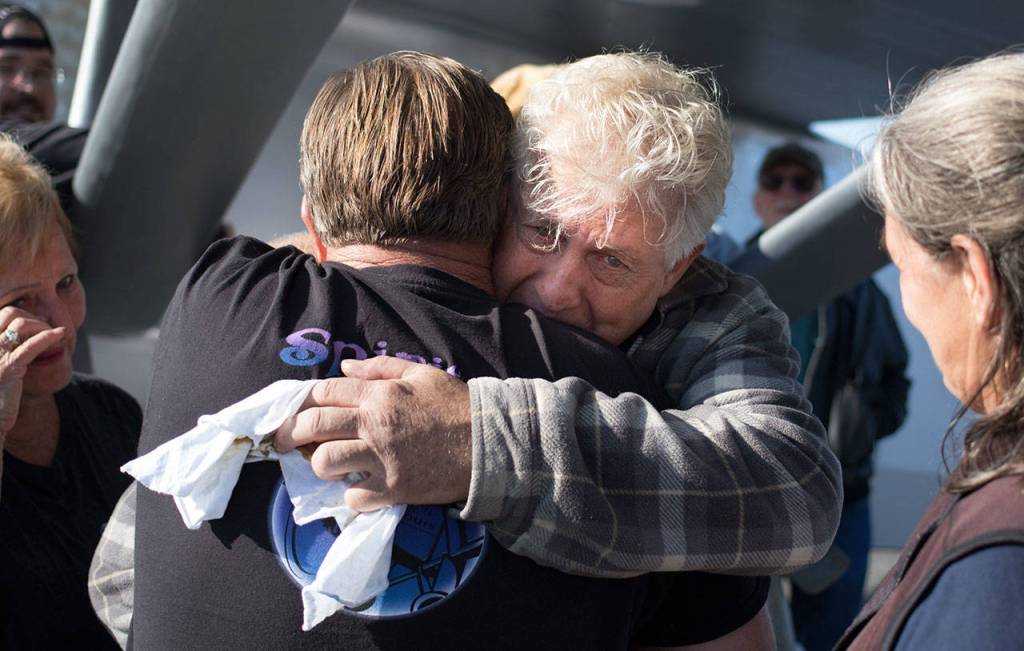 John Norman hugs Jeff Sandstorm after Normans replica of the Spirit of St. Louis finished its first flight from Arlington Municipal Airport on July 28. Sandstorms brother Ty was instrumental in getting the exacting details of the plane, but passed away before the flight happened. (Andy Bronson / The Herald)
