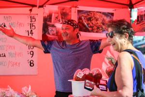 Bubba of Bubbas Salsa greets the new location with Peggy Webb (right) Sunday morning at Everett Farmers Market in Everett in August 4, 2019. (Kevin Clark / The Herald)
