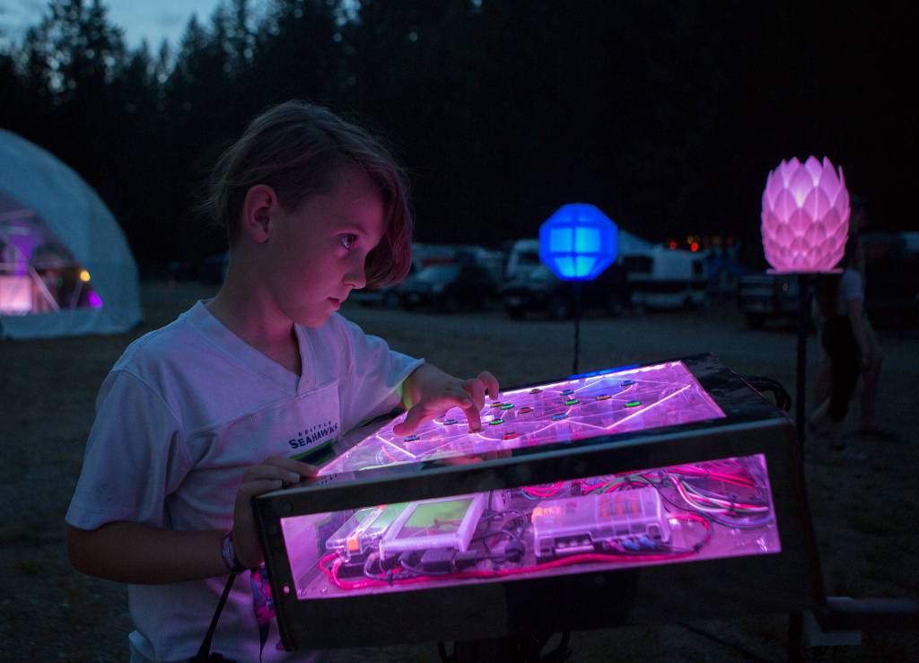 Max Love, 9, plays with the Astral Cockpit art installation during the first day of Summer Meltdown on Thursday, Aug. 1, 2019 in Darrington, Wash. (Olivia Vanni / The Herald)