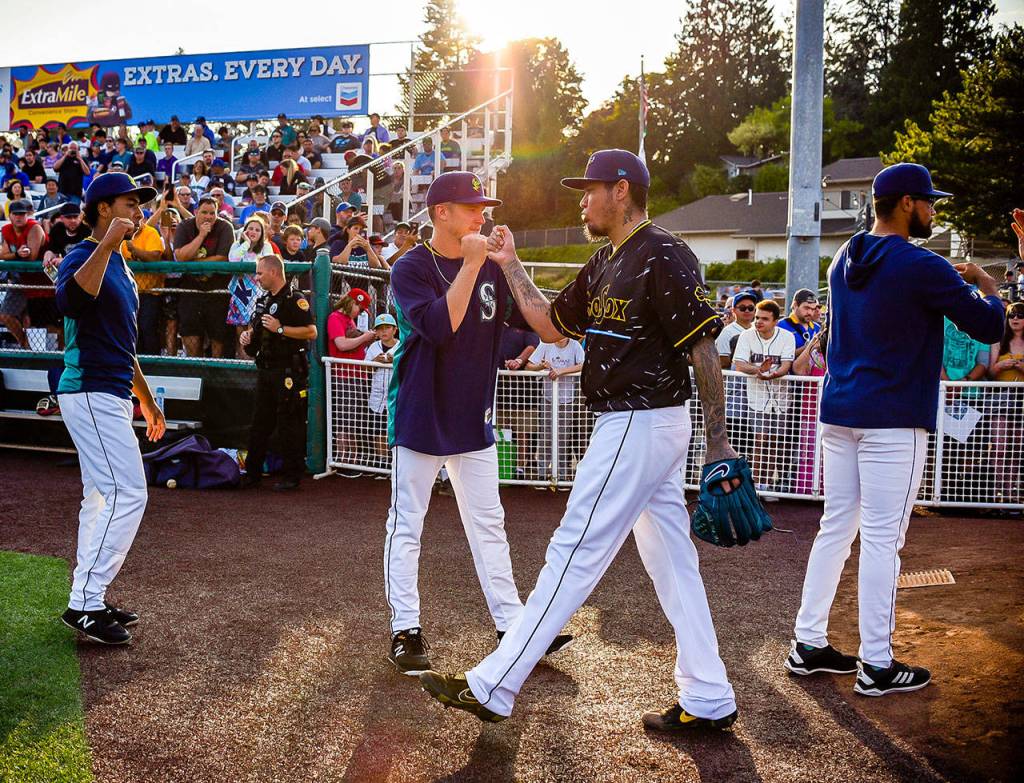 Mariners pitcher Felix Hernandez (center) fist-bumps his AquaSox teammates after warming up before a rehab appearance against the Indians on Aug. 2, 2019, at Funko Field at Everett Memorial Stadium. (Dougal Brownlie / For The Herald)