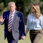 President Donald Trump waves to members of the media as he and first lady Melania Trump walk across the South Lawn of the White House in Washington on Sunday as they return from Bedminster, New Jersey. (AP Photo/Andrew Harnik)