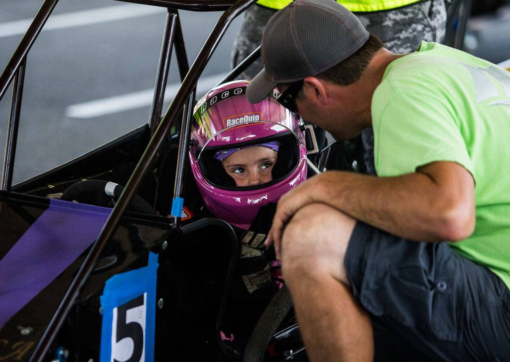 Jessica Davis, 8, gets a pep talk from her crew chief, Paul Wagar, before the start of her race at the Washington Quarter Midgets Associations Wild Wild West race on Aug. 4 in Monroe. (Olivia Vanni / The Herald)