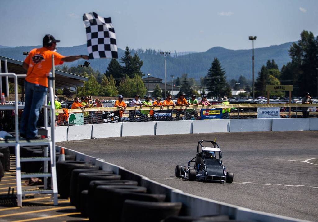 A checkered flag signals the end of a race at the Washington Quarter Midgets Associations Wild Wild West race on Aug. 4 in Monroe. (Olivia Vanni / The Herald)
