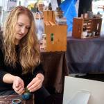 Angie Rolly of Lynnwood pots a succulent at the Edmonds Farmers Market. (Kevin Clark / The Herald)