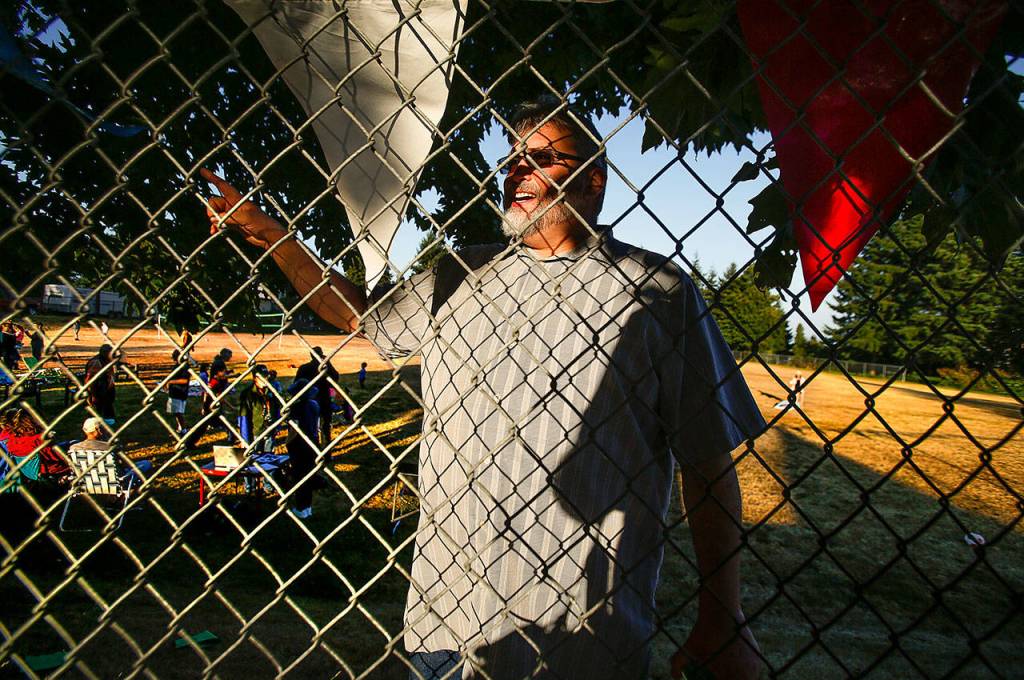 From inside the fence, Port Gardner Neighborhood resident Richard Blalock directs someone to the Norton playfield entry. (Dan Bates / The Herald)