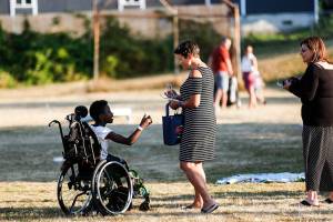 Everett Mayor Cassie Franklin gives a pair of sunglasses to an 11-year-old girl named Deborah during a National Night Out gathering at Norton playfield in the Port Gardner Neighborhood. Looking on Tuesday is Andrea Tucker, leader of the Port Gardner Neighborhood Association. (Dan Bates / The Herald)