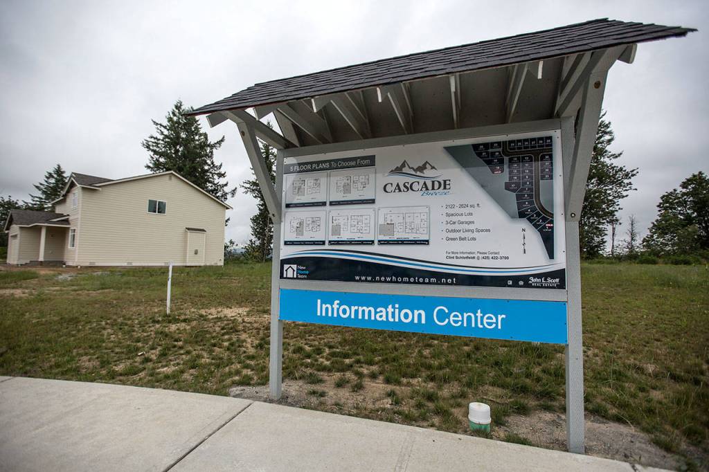 An informational sign stands next to the entrance of the Cascade Breeze home construction area on Thursday in Sultan. (Olivia Vanni / The Herald)