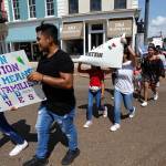 Children of mainly Latino immigrant parents hold signs in support of them and those individuals picked up during an immigration raid at a food processing plant following a Spanish Mass at Sacred Heart Catholic Church in Canton, Mississippi, on Sunday. The raids Wednesday at poultry plants in Mississippi have spurred churches that have been key to providing spiritual and emotional comfort to workers to now step up to provide material aid to jailed or out-of-work church members. (AP Photo/Rogelio V. Solis)