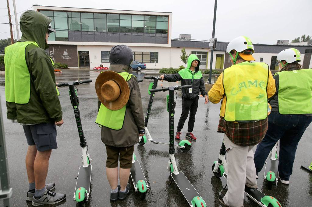 Renzee Sto-Tomas (center) leads a Lime e-scooter safety class Aug. 10 in Everett, which was mulling over whether to continue to allow the devices to operate in the city. (Kevin Clark / The Herald)