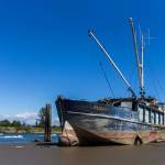 People on jet skis and boats drive past the Hannah Marie, formerly called the Midas, that was run aground along the banks of the Snohomish River, on July 3, 2018, in Everett. (Olivia Vanni / Herald file)