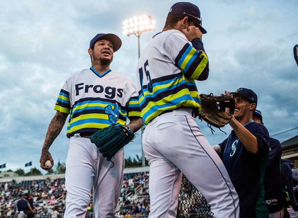Mariners pitcher Felix Hernandez jokes with AquaSox players as he makes his way to the dugout Wednesday during a rehab appearance at Funko Field in Everett. (Olivia Vanni / The Herald)