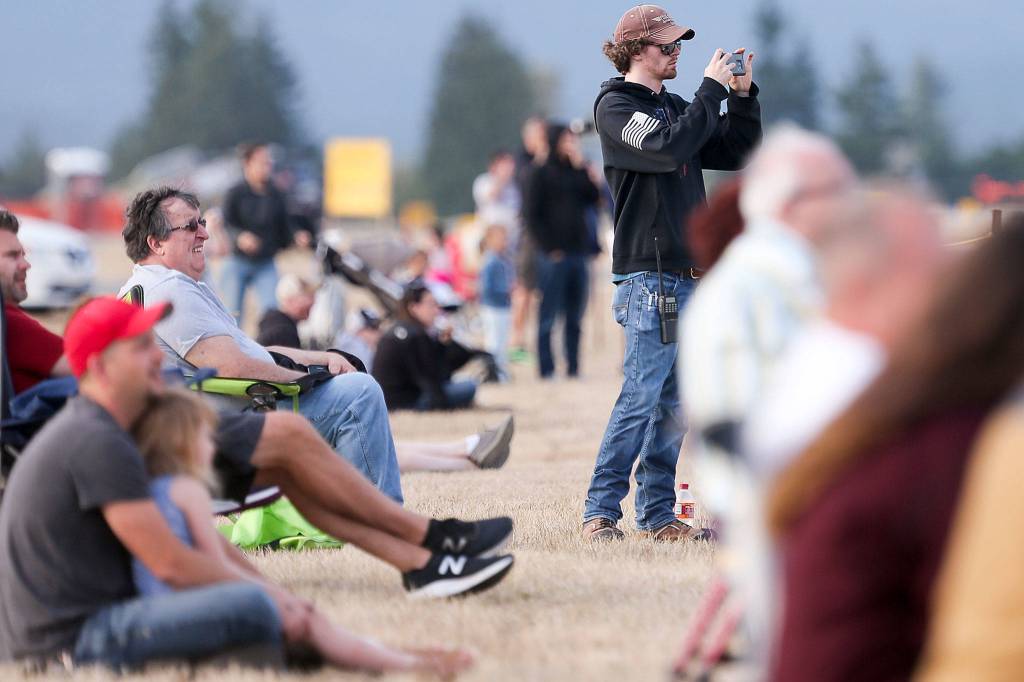 Spectators enjoy the Arlington Fly-in at Arlington Municipal Airport on Friday evening. (Kevin Clark / The Herald)